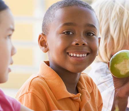 photo of young boy eating an apple