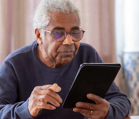 photo of a senior reading tablet